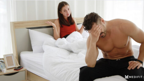 A man embarrassed in bed due to erectile dysfunction Medifitpro.com