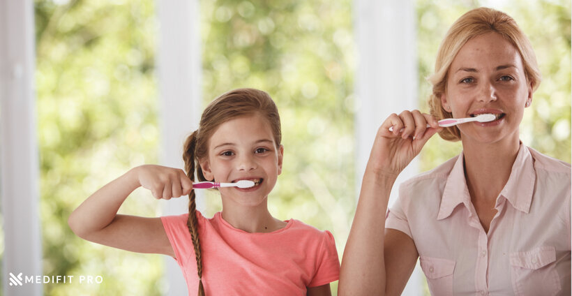 Mother teaching her child how to brush teeth