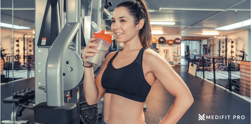 A young fit woman drinks in protein shake in the gym Medifitpro.com